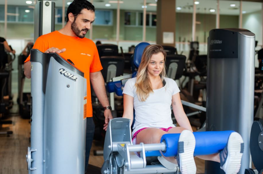 Nós falamos muito por aqui dos benefícios de realizar alguma atividade física. Músculos definidos, barriga chapada, perda de peso, prevenção de doenças, controle de diversos distúrbios.. Mas quanto tempo de academia para ver resultado? Bom, isso vai depender de alguns fatores que você vai conhecer neste artigo. Não sai daqui se você realmente quiser descobrir a resposta! Quanto tempo para ver resultado de academia? Você abandonou a vida sedentária e hábitos prejudiciais à saúde. Agora, é uma nova pessoa. Está se exercitando regularmente e se alimentando melhor. Mas há um questionamento bem comum (e compreensível) que iniciantes da vida fitness têm: “Quanto tempo de academia para começar a ver resultados?” Isso depende do seu metabolismo, do seu objetivo, da intensidade e tipo de treino e do seu programa alimentar. Uma coisa importante que você deve ter em mente é que deve estabelecer metas realistas para seus objetivos. Se você está acima do peso, por exemplo, não pense que irá conseguir emagrecer 30 quilos em um mês com facilidade. Para cumprir essa meta, você precisaria realizar uma dieta muito radical, se exercitar todos os dias por muitas horas e talvez recorrer a remédios de emagrecimento prejudiciais à sua saúde. E depois desse sacrifício todo, ainda correria o risco de ganhar mais peso do que perdeu. Isso porque pessoas que buscam objetivos de curto prazo tendem a relaxar com os exercícios e a alimentação logo depois que cumprem sua meta. E não é isso o que você quer, ou é? Assim sendo, tenha em mente que você conseguirá alcançar seus objetivos, mas isso não acontecerá de uma hora para outra. E para alcançá-los precisará se dedicar bastante, mas nada que esteja fora do seu alcance: Você deve se exercitar por 3 vezes na semana, pelo menos; Reduzir o consumo de gordura, açúcar, sódio e alimentos processados; Inserir mais frutas, legumes e verduras na sua alimentação; Beber 2 litros de água e dormir em torno de 8 horas por dia, ou conforme sua necessidade. Há pessoas que precisam beber mais água ou dormir menos horas por dia. Você não precisa adotar um estilo de vida totalmente radical. Pode sair para o happy hour com os colegas do trabalho ou comer uma sobremesa após o almoço de domingo quando sentir vontade. Você só precisa se atentar para não abusar e fazer da exceção algo corriqueiro. Lembre-se: se você conseguir se manter na linha, alcançará seus objetivos mais rapidamente. Quanto tempo de academia para ver os resultados: dicas para reconhecer os sinais Muito provavelmente você está ansioso para ver os resultados dos seus esforços. Mas, será que você está no caminho certo? Vamos te apresentar os 3 principais sinais para te ajudar a identificar: A dor muscular permanece após o treino Em iniciantes, é comum que sintam algum desconforto na musculatura nos primeiros dias. Isso acontece porque as fibras musculares sofrem um estiramento e passam por um processo de inflamação. É assim que ocorre a hipertrofia muscular (aumento dos músculos). A dor se intensifica nas primeiras 24 horas e podem permanecer por até 72 horas de forma mais moderada. Esse prazo também vai variar conforme a intensidade e a frequência da atividade que você realiza. Mais facilidade para realizar os exercícios Após algum tempo praticando os exercícios de musculação Ribeirão Preto, ou qualquer outra atividade, você vai perceber que eles ficarão mais fáceis. O que não quer dizer que eles vão parar de produzir efeitos, apenas que seu corpo está ganhando força e resistência. Contudo, quando isso acontecer, pode ser a hora de aumentar a intensidade dos exercícios, seja com o aumento dos pesos ou das repetições. Seu personal trainer irá te indicar qual é a melhor opção. Você dorme melhor e tem mais disposição Logo após o exercício, você pode ficar um pouco cansado, devido ao gasto energético que teve, mas as atividades físicas estimulam a produção de melatonina, o hormônio responsável por regular o sono. Então, se você tem problemas de insônia ou dificuldade em pegar no sono, conseguirá dormir muito melhor. E isso também afeta a disposição, porque à noite conseguiremos repor adequadamente as energias para o próximo dia. Além disso, substâncias como a serotonina e endorfina, que são enviadas ao organismo durante a prática física, melhoram o humor e a sensação de bem-estar. Leia mais: Spinning Ribeirão Preto Quanto tempo de academia para ver os resultados para cada objetivo? Resultados sutis são mais fáceis de serem percebidos nas primeiras semanas, enquanto as mudanças mais radicais acontecem em um período de médio a longo prazo. Ou seja, há uma fase em que os efeitos das suas idas às academias Ribeirão Preto começam a surgir: Inserir tabela Fases de resultados da academia Do 7º mês em diante, dependendo do seu treino, a hipertrofia entra em um ritmo mais acelerado até que se estabiliza. E todos os ganhos que você obteve até o momento permanecem. Quanto tempo de treino na academia para ver resultado? Como você pode ver, é um processo gradual, que pode ter pequenas alterações de uma pessoa para outra. Por causa da genética, algumas pessoas têm mais facilidade para ganhar massa magra, enquanto outras têm mais dificuldade para perder peso. Se você continuar praticando atividades físicas, conseguirá sim alcançar seus objetivos, não importa o tempo que leve. Mas para te ajudar a conquistá-los, a Companhia Athletica disponibiliza programas personalizados para cada objetivo. Clique aqui para saber mais sobre os Programas de Resultados da Cia Athletica Ribeirão Preto.