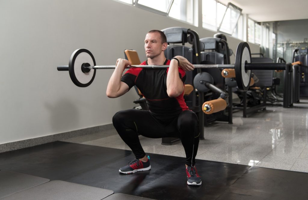 O agachamento é um exercício bem simples e você pode executá-lo com o auxílio de algum acessório, como uma barra, kettlebell ou halter (dumbell).