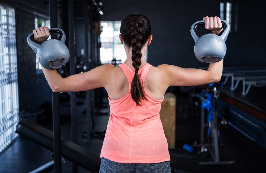 Você também pode realizar este exercício em pé ou sentado, porque o foco é desenvolver os músculos dos ombros, com auxílio de kettlebells ou halteres.