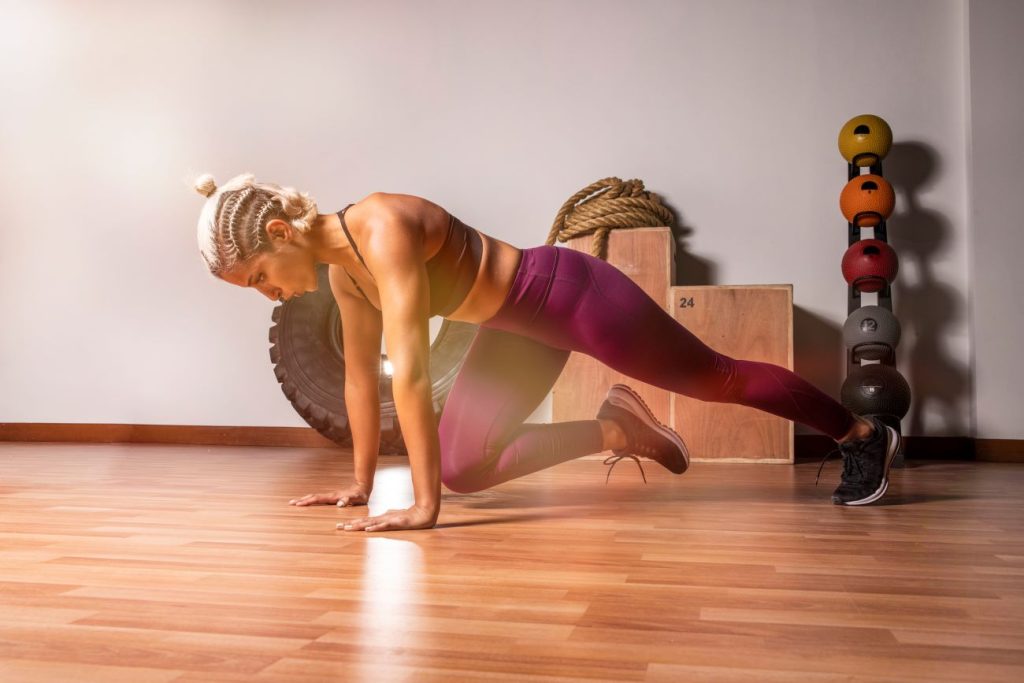 mulher realizando o exercicio mountain climber para fortalecimento dos musculos do core