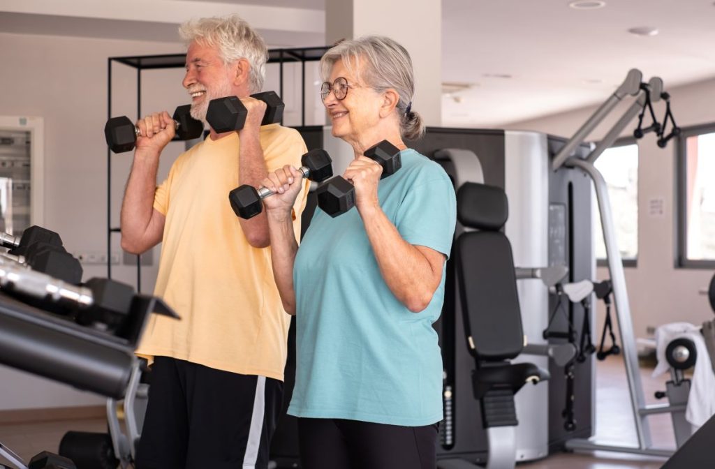 Casal da terceira idade fazem exercícios para idosos em academia