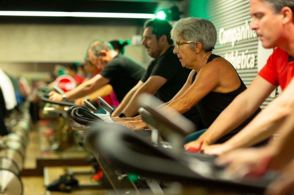 grupo de pessoas fazendo cardio na academia fazendo spinning