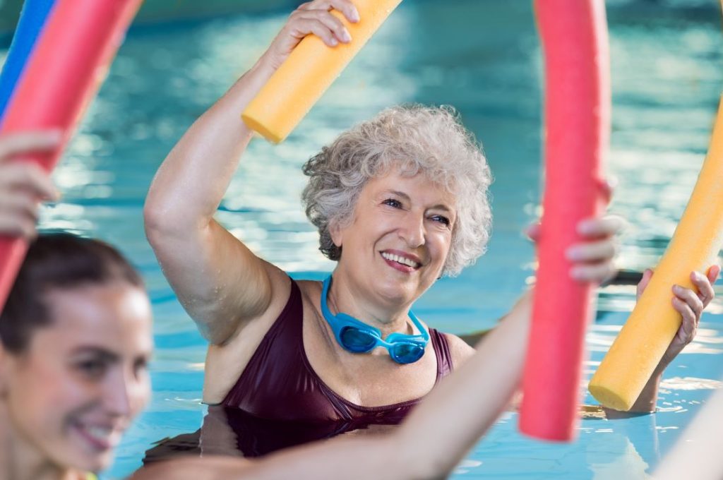 idosa contente e ativa praticando hidroginastica