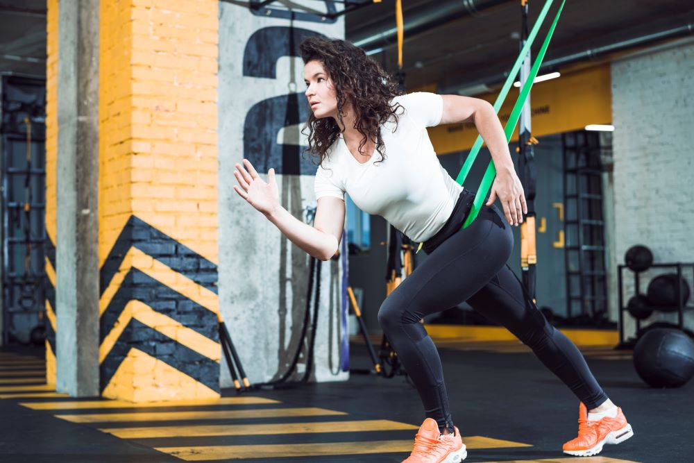 mulher realizando treino funcional corrida com cinta