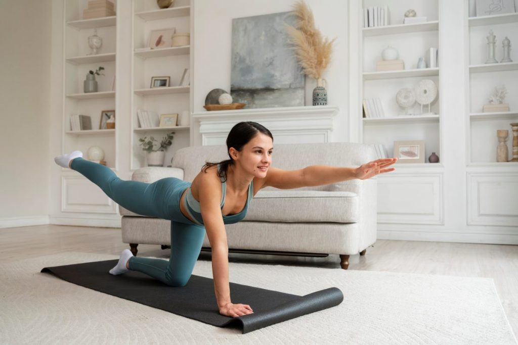 uma mulher praticando um dos exercícios de equilíbrio conhecidos como "Superman" em um ambiente doméstico aconchegante