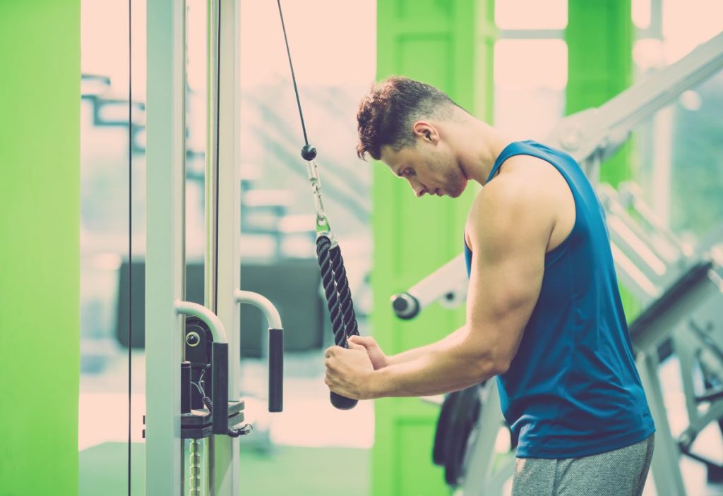 homem realizando um exercício de tríceps conhecido como "tríceps corda"