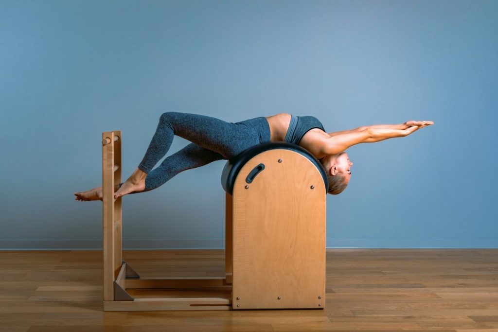 mulher realizando um exercício de Pilates para a coluna.