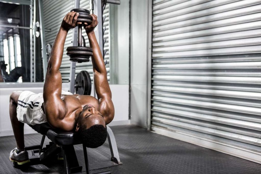 homem realizando um exercício de pullover em um BANCO