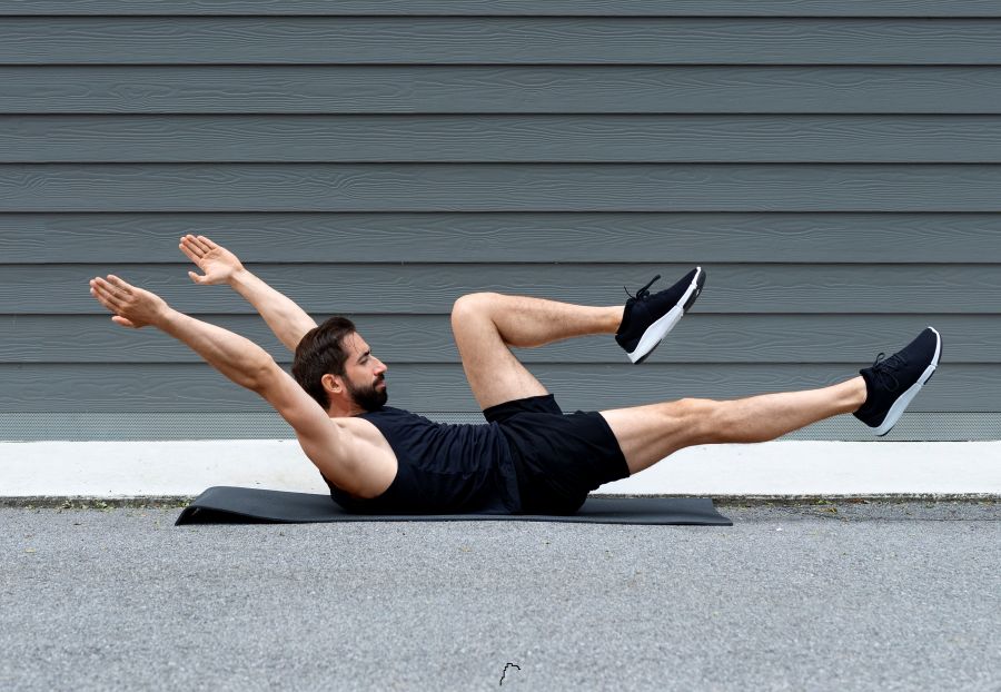 Homem realiza dead bug como exercícios para core.