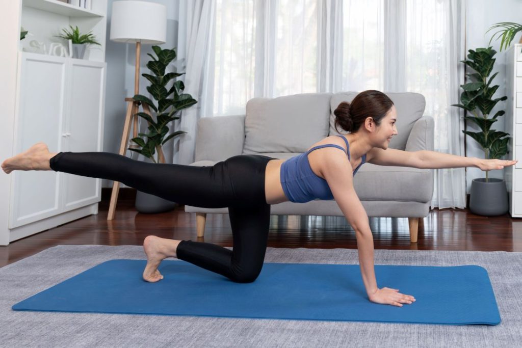 Mulher realiza bird dog como exercícios para core.