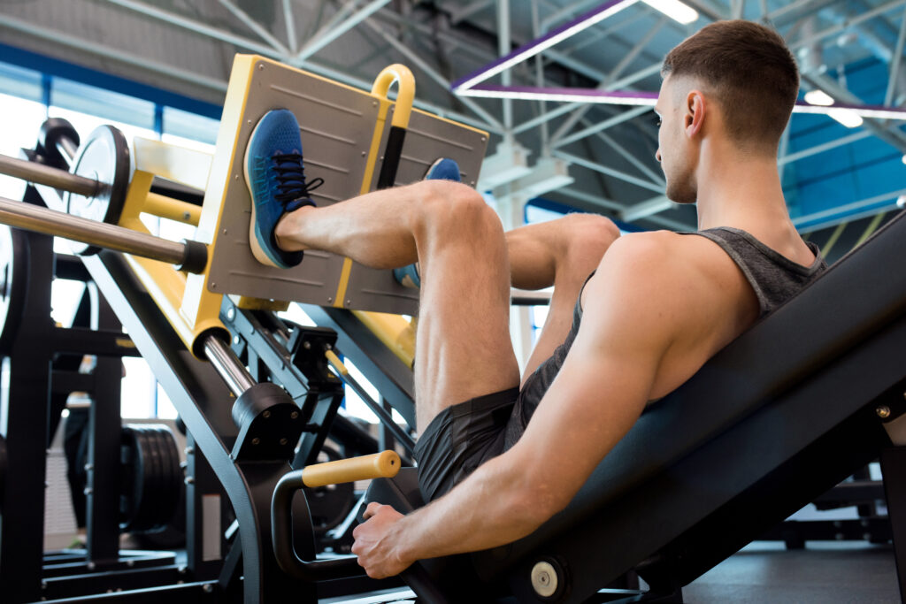 Pessoa realizando leg press 45° em academia, executando exercício para fortalecimento dos músculos das pernas com foco em força, estabilidade e hipertrofia.